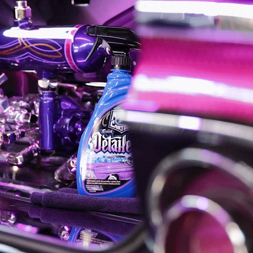 Turtle Wax Quick Detailer spray and cleaning cloth near custom lowrider engine with bright purple paint.
